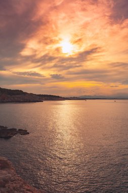 Denizde güzel bir gün doğumu. Okyanusun üzerindeki renkli bir gökyüzünün manzarası. Turuncu ve mavi bulutlar. Deniz manzarası arkaplanı ve duvar kağıdı.