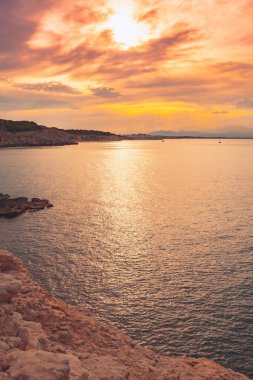 Denizde güzel bir gün doğumu. Okyanusun üzerindeki renkli bir gökyüzünün manzarası. Turuncu ve mavi bulutlar. Deniz manzarası arkaplanı ve duvar kağıdı.