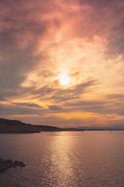 Denizde güzel bir gün doğumu. Okyanusun üzerindeki renkli bir gökyüzünün manzarası. Turuncu ve mavi bulutlar. Deniz manzarası arkaplanı ve duvar kağıdı.