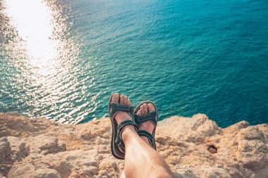 Parmak arası terlikleri olan genç bir adamın kumsalda gün batımına bakışı inanılmaz. Akdeniz yaz tatillerinde dinlenir. Tatil kavramı.