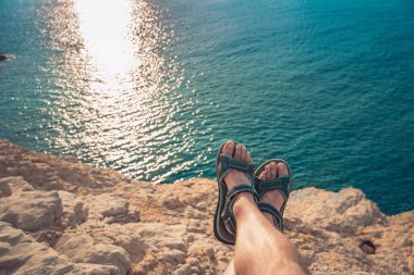 Parmak arası terlikleri olan genç bir adamın kumsalda gün batımına bakışı inanılmaz. Akdeniz yaz tatillerinde dinlenir. Tatil kavramı.