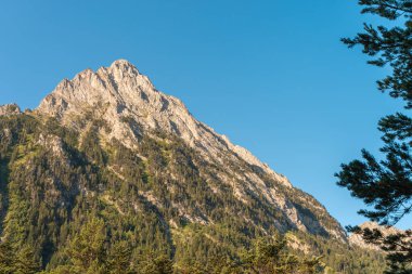 Gün batımında muhteşem manzara dağları. Dağların üzerinde renkli bir gökyüzünün manzarası. Turuncu ve mavi bulutlar. Macera yolculuğu konsepti. Duvar kağıdı arka plan doğa baskısı.