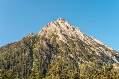 Gün batımında muhteşem manzara dağları. Dağların üzerinde renkli bir gökyüzünün manzarası. Turuncu ve mavi bulutlar. Macera yolculuğu konsepti. Duvar kağıdı arka plan doğa baskısı.