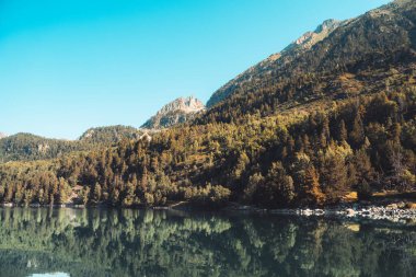 Gün batımında muhteşem göl manzarası. Suda yansıması olan çarpıcı bir manzara. Doğa kavramının güzelliği. Seyahat ve tatil duvar kâğıdı, ekran koruyucu, güzel ve vahşi bir arka plan..