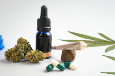 Beyaz arka planda CBD yağı, kapsüller ve kenevir tomurcukları. Organik ve doğal kenevir bazlı kozmetik ve güzellik ürünleri. Tıbbi kenevir konsepti. Alternatif tıp. Metin için alanı kopyala.
