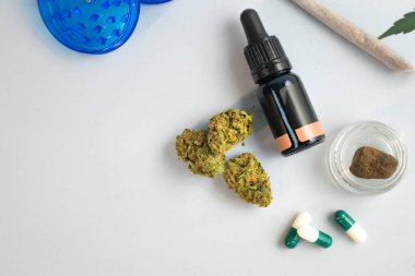 Beyaz arka planda CBD yağı, kapsüller ve kenevir tomurcukları. Organik ve doğal kenevir bazlı kozmetik ve güzellik ürünleri. Tıbbi kenevir konsepti. Alternatif tıp. Metin için alanı kopyala.