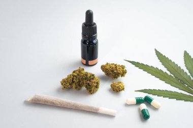 Beyaz arka planda CBD yağı, kapsüller ve kenevir tomurcukları. Organik ve doğal kenevir bazlı kozmetik ve güzellik ürünleri. Tıbbi kenevir konsepti. Alternatif tıp. Metin için alanı kopyala.