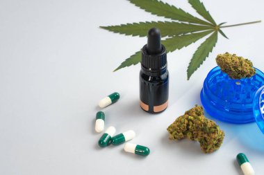 Beyaz arka planda CBD yağı, kapsüller ve kenevir tomurcukları. Organik ve doğal kenevir bazlı kozmetik ve güzellik ürünleri. Tıbbi kenevir konsepti. Alternatif tıp. Metin için alanı kopyala.