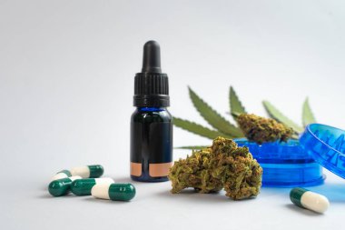 Beyaz arka planda CBD yağı, kapsüller ve kenevir tomurcukları. Organik ve doğal kenevir bazlı kozmetik ve güzellik ürünleri. Tıbbi kenevir konsepti. Alternatif tıp. Metin için alanı kopyala.