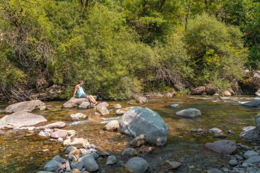 Çekici bir adam, Dreamer nehrinde dinlenirken ayakta durup manzarayı seyrediyor. Yaşam tarzı özgürlüğü. Doğa kavramının güzelliği. Seyahat ve tatil kavramı.