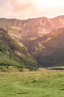 Gün batımında güzel dağlar manzarası. Dağların üzerinde renkli bir gökyüzünün manzarası. Turuncu ve mavi bulutlar. Macera yolculuğu konsepti. Duvar kağıdı arka plan doğa baskısı.
