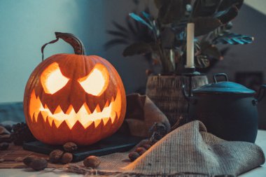 Korkunç cadılar bayramı balkabağı. Renkli ışıkları olan karanlık bir arka plan. Cadılar Bayramı teması. Korkunç kartpostal. Korkunç surat. Kart daveti. Yanan mumları olan bir fener, hayat dolu. Ürkütücü, şeytani, kutlama.