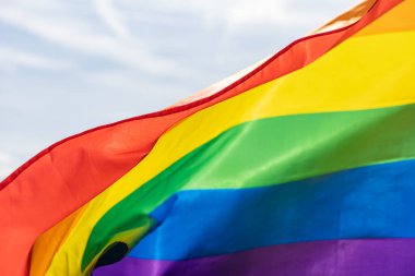 Gökkuşağı bayrağı (LGBT hareketi) güneşli mavi gökyüzü arka planında. Renkli gay bayrağı dalgalanıyor.