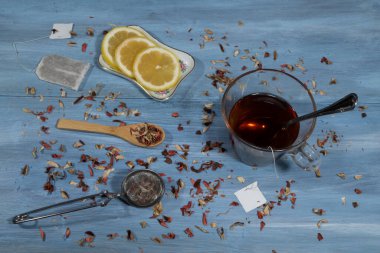 Limon tepsisiyle çay fincanının yakın plan görüntüsü ve masadaki tahta kaşıkta eritmek için yapraklar.