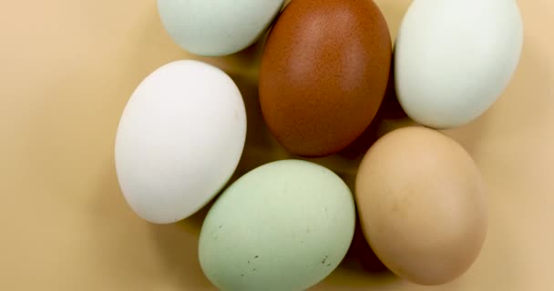 Natuurlijk Gekleurde Eieren Draaien Een Beige Achtergrond — Stockvideo