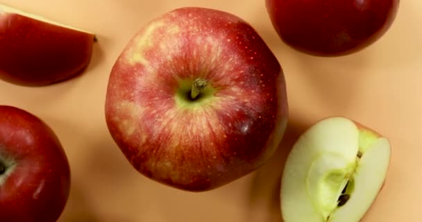 Turuncu Arka Planda Dönen Kırmızı Elmalar Izole Edilmiş Meyveler — Stok video