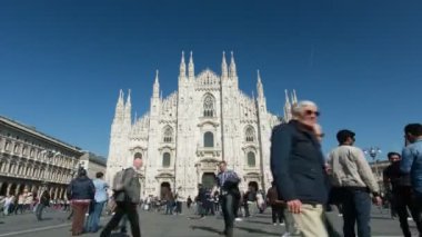 Duomo 'nun zamanaşımı ve güneşli bir öğleden sonra Milano, İtalya, 4K' da yürüyen insanlar.. 