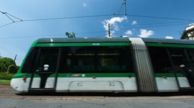 Giuseppe Garibaldi 'nin anıtının altındaki Cairoli Meydanı' nda, güneşli bir günde arka planda Sforzesco Kalesi 'nin önünden geçen insanların zaman aşımı.