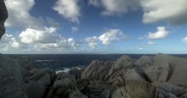 Capo Testa Sardunya 'dan deniz manzarası bulutlu ve rüzgarlı bir günde kayaların arasında, zaman aşımı, 4K.