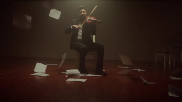 Skrzypek gra na skrzypcach sam na scenie, nuty spadają z powietrza — Wideo stockowe
