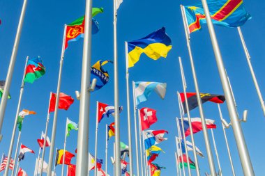 Aralarında Ukrayna, Arjantin, Eritre, DR Kongo, Bosna, Küba, İsviçre, Panama ve Angola 'nın da bulunduğu uluslararası bayraklar, Doha, Katar' da açık mavi gökyüzüne karşı rüzgarda sallanıyor.