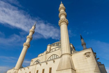 Arka planda park ve mavi gökyüzü, Tiran ve Arnavutluk olmak üzere çağdaş İslami dini mimariyi temsil eden minareleri olan büyük beyaz Namazgah Camii binası