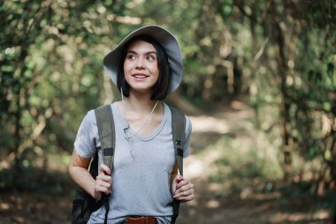 Orman yürüyüşü yapan kadın güz mevsiminde doğa arka planında yürüyor. Genç beyaz kadın aktif insan yaşam tarzı yürüyüşü yapıyor sırt çantası takıyor ve dışarıda egzersiz yapıyor.. 
