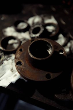 Klasik bir arabaya tekerlek yerleştirmek. Eski araç yenileme konsepti. Kirli, yağlı bir peçeteye takılmış yıpranmış tekerlek. Metal desenli arkaplan.