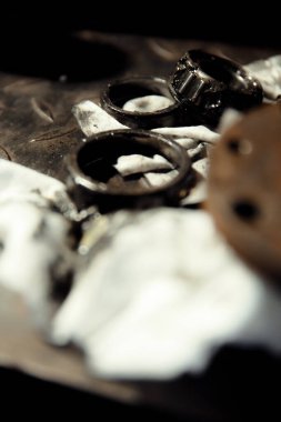 Klasik bir arabaya tekerlek yerleştirmek. Eski araç yenileme konsepti. Kirli, yağlı bir peçeteye takılmış yıpranmış tekerlek. Metal desenli arkaplan.