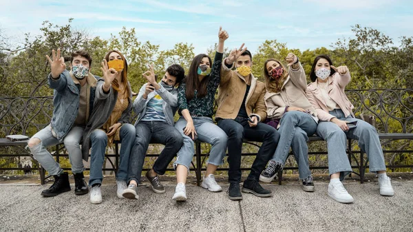 Generation z young people sitting on a bench and using smartphone. Concept of young people addicted to technology and social network.