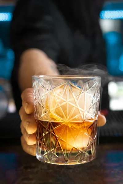 Unrecognizable Bartender Giving Glass Negroni Smoking Cocktail Ice Lemon Thru — Stock Photo, Image