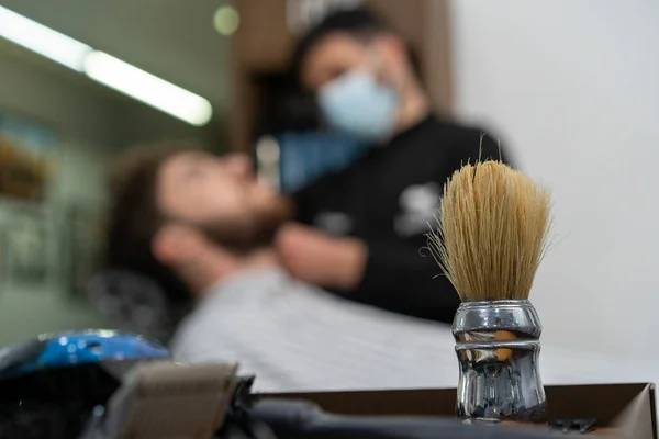 Spazzola Barbiere Con Proprietario Cliente Irriconoscibile Sfocata Sullo Sfondo Stilista — Foto Stock