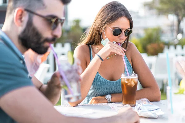 若い人たちの再会屋外アルコールカクテルを飲むモヒート顔マスクを下げて — ストック写真