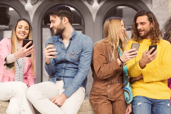 Glad Grupp Ungdomar Som Går Och Använder Sina Smartphones — Stockfoto