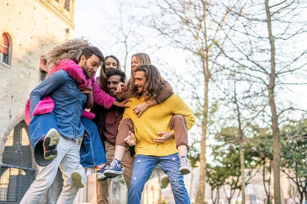 Portrait of young people hugging, talking and having fun together outdoors.