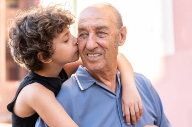 Gülümseyen çocuk çimlerin üzerinde uzanmış gülümsüyor ve parmaklarıyla zafer işareti yapıyor. Doğada eğlenen çocuklar ve pozitif duygu yaşam tarzı konsepti.