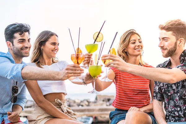 Yazın dışarıda kokteyl bardaklarını tokuşturan bir grup genç. Arkadaşların bir araya gelip dışarıda kafede eğlenmesi alkollü içkiler içmesi.