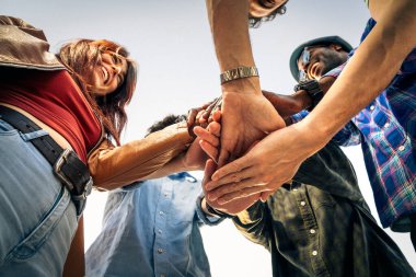 Mutlu, çok kültürlü bir arkadaş grubunun el ele tutuşup takım çalışmasını ve birliğini sembolize ettiği düşük açılı bir bakış açısı..