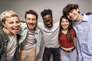 Stüdyoda mutlu bir şekilde poz veren bir grup çok kültürlü genç, neşe, bağlantı ve otantik insan ilişkileri sergiliyorlar.