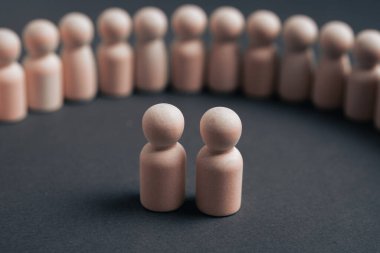 Yeni bir yönetici ortaklık ya da liderlik ikilisini temsil eden iki tahta mandallı bebek, şirket yönetim ve entegrasyon sürecini gösteren yarı daire takım üyelerine tanıtılıyor..