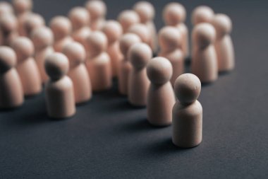 Bir gruptan ayrılmış, bireyselliği, liderliği, dışlanmayı, izolasyonu, çeşitliliği veya bir iş veya sosyal bağlamda öne çıkmayı sembolize eden tek bir tahta figürün kavramsal görüntüsü.