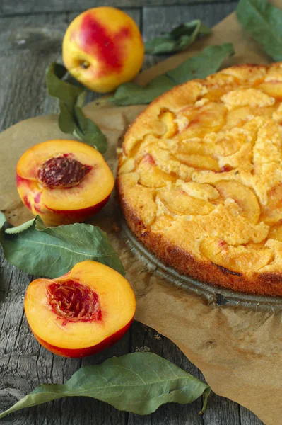 Torta di pesche e frutta fresca su sfondo di legno — Foto Stock