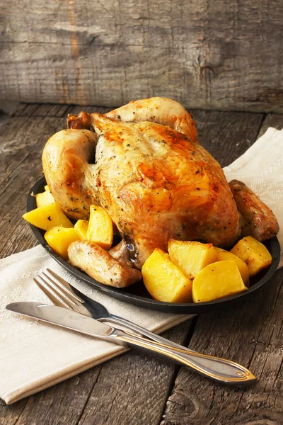 chicken baked with potatoes on a cast iron pan