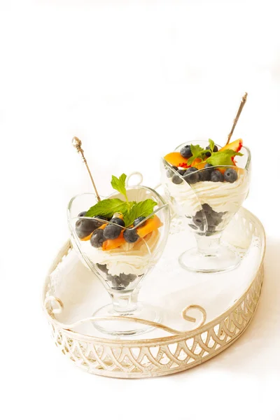Dessert cagliata con pesche e mirtilli su sfondo bianco — Foto Stock