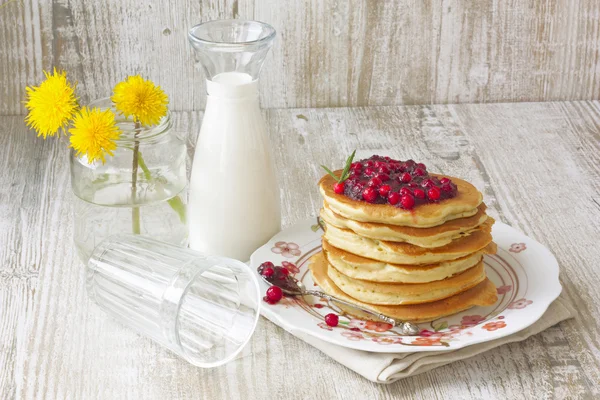 Pancake with lingonberry jam and a milk bottle — Stock Photo, Image