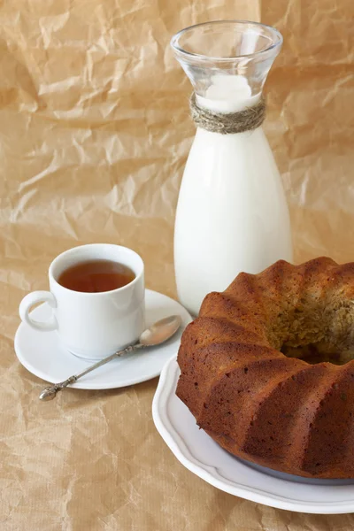 Torta di banana fatta in casa su un piatto bianco, tazza di tè e latte — Foto Stock