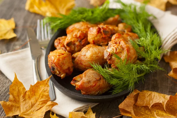 Baked chicken drumsticks and fresh dill on a wooden background — Stock Photo, Image
