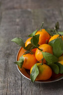  bir tepsi ahşap bir zemin üzerine yeşil yaprakları ile mandalina