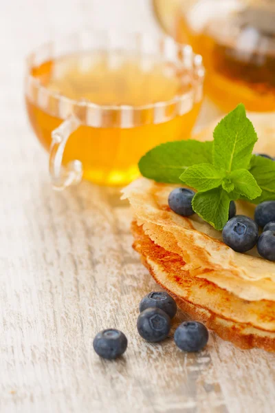 Crepes with blueberries and mint and a cup of tea — Stock Photo, Image