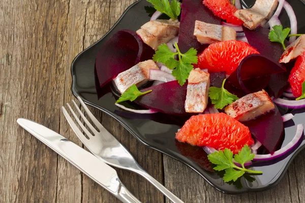 Skålen med en sallad av sill, rödbetor och grapefrukt — Stockfoto